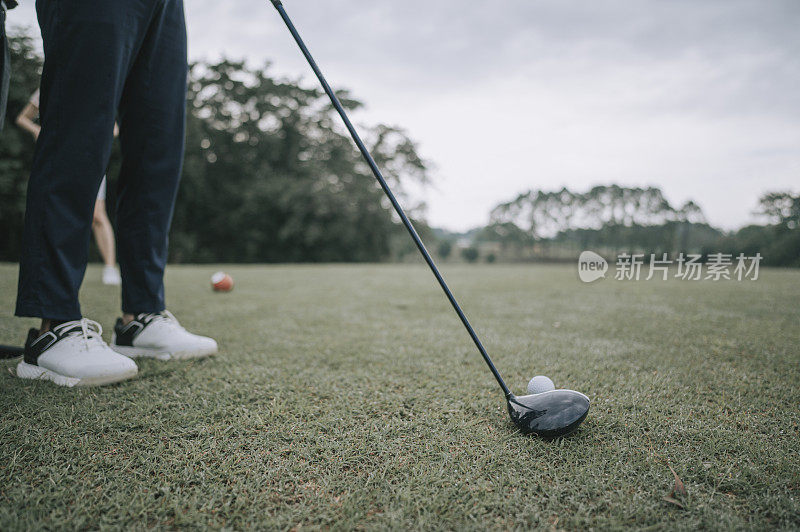 Asian chinese young couple golfer teeing off and swing his driver club on the golf course